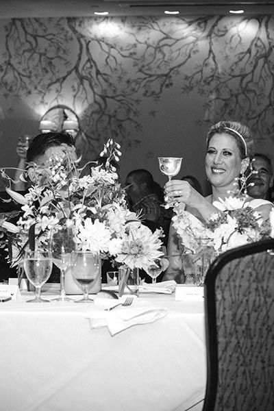 brice and groom toasting glasses at wedding reception