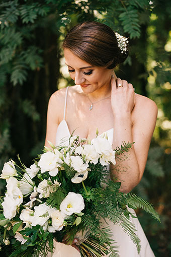 bride smiles and looks down at her bouquet